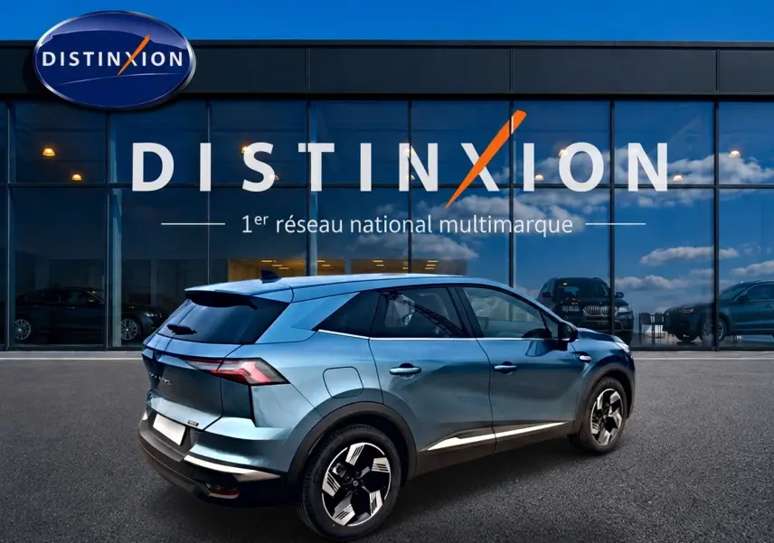 Renault Symbioz bleu mercure en 3/4 arrière droit, avec jantes alliage et toit noir devant showroom Distinxion.