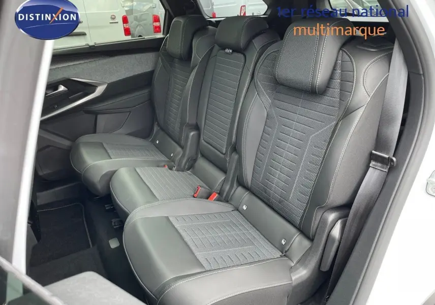Vue intérieure côté droit sur les sièges arrière en cuir noir du Peugeot 5008 Hybrid 2025 blanc toit noir.