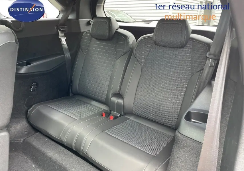 Vue intérieure sur la banquette arrière en cuir noir du Peugeot 5008 Hybrid 2025 avec ceinture de sécurité visible.