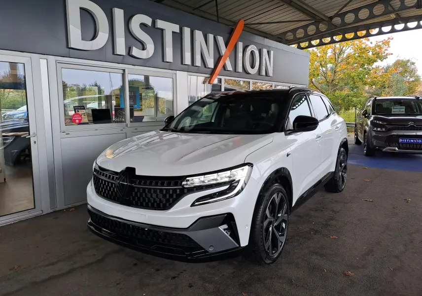 Renault Austral E-Tech blanc nacré avec toit noir, vu en 3/4 avant droit sous abri de concession.