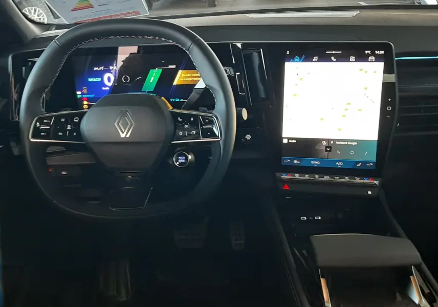 Vue intérieure du tableau de bord et volant du Renault Austral E-Tech Hybrid 2025 avec écran tactile central allumé.