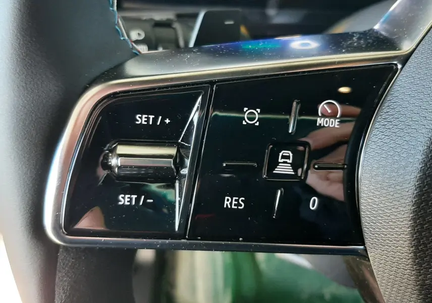 Gros plan sur les commandes gauche du volant du Renault Austral 2025, boutons noirs avec marquages blancs.