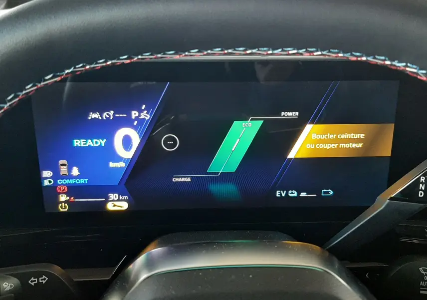 Tableau de bord numérique du Renault Austral E-Tech hybride, affichant l'état prêt et consignes de sécurité, vue depuis le poste de conduite.