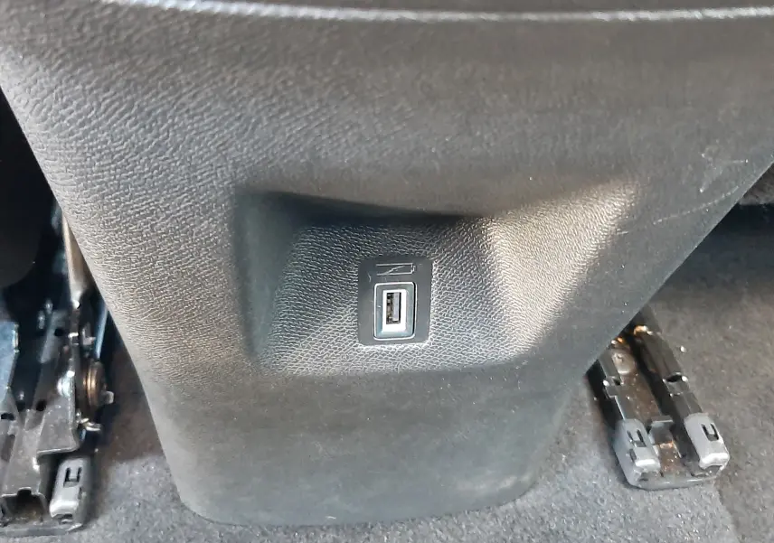 Prise USB intégrée au bas de la console centrale arrière d’un Citroën C5 Aircross hybride gris platinium, vue rapprochée.
