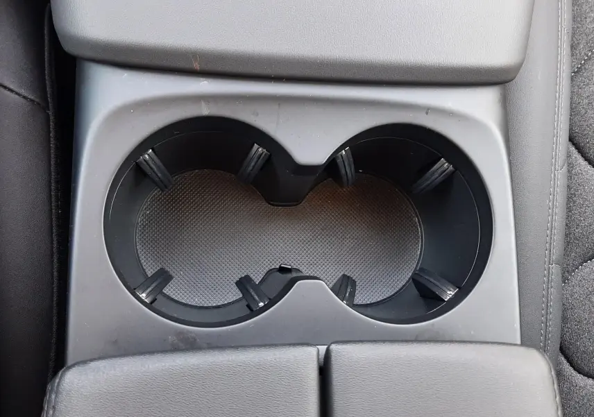 Gros plan sur les porte-gobelets centraux noirs du Citroën C5 Aircross hybride 2025, intérieur en cuir noir.