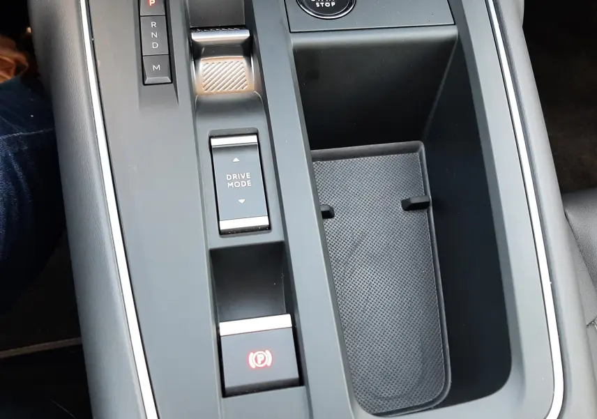 Vue rapprochée de la console centrale grise platinium du Citroën C5 Aircross hybride 2025 avec boutons de démarrage et mode de conduite.