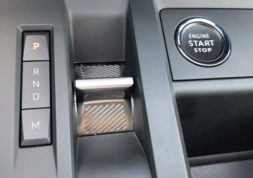 Gros plan sur la console centrale noire du Citroën C5 Aircross hybride avec bouton start/stop et levier de vitesses électronique.