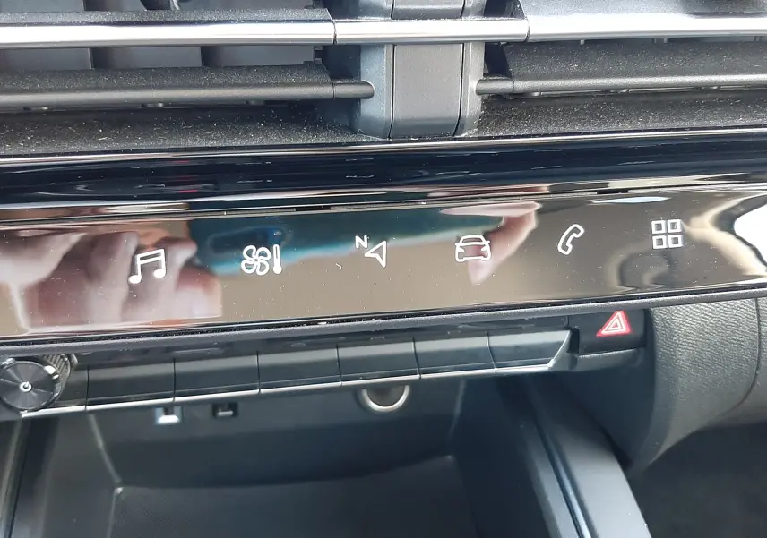 Vue rapprochée de la console centrale noire du Citroën C5 Aircross hybride 2025 avec commandes tactiles et aérateurs.