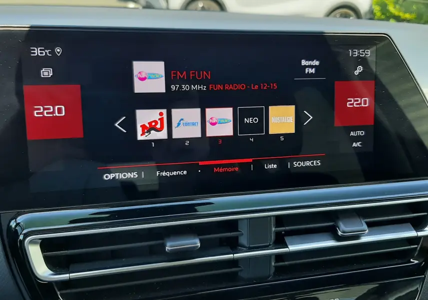 Vue rapprochée de l'écran multimédia et des commandes de climatisation du Citroën C5 Aircross hybride gris platinium.