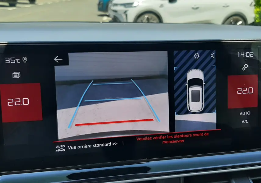Vue de l'écran intérieur du Citroën C5 Aircross hybride gris platinium montrant la caméra de recul et l'affichage de la climatisation.