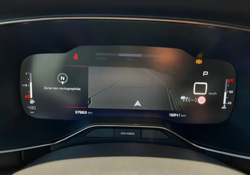 Vue rapprochée du tableau de bord numérique du Citroën C5 Aircross hybride 2025 affichant la navigation et les indicateurs de vitesse et température.