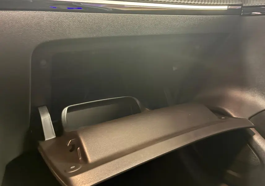 Intérieur de la Peugeot 208 1.5 BlueHDi 100 Style 2021, boîte à gants ouverte côté passager, finition noire.