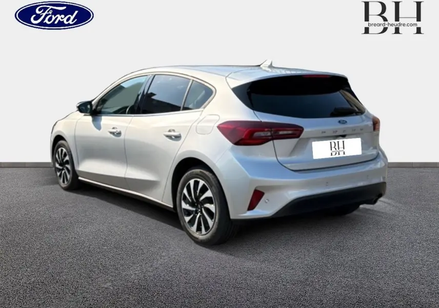 Vue 3/4 arrière droite d'une Ford Focus gris lunaire métallisé avec vitres arrière surteintées et feux LED distinctifs.