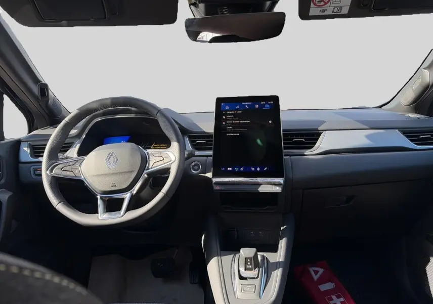 Vue intérieure avant du tableau de bord noir étoile de la Renault Symbioz 1.8 e-tech avec écran tactile vertical et volant multifonction.