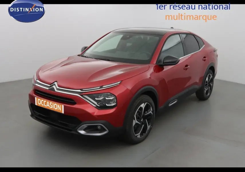 Citroën C4 X rouge Elixir métal vue 3/4 avant droit avec signature lumineuse LED et jantes bi-ton.