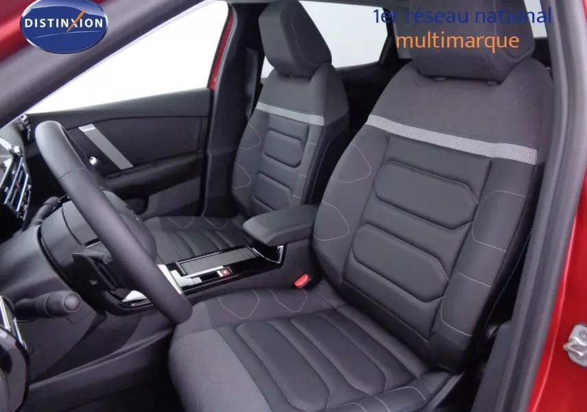 Vue intérieure côté conducteur de la Citroën C4 X rouge Elixir, sièges en tissu et cuir noir avec surpiqûres contrastées.