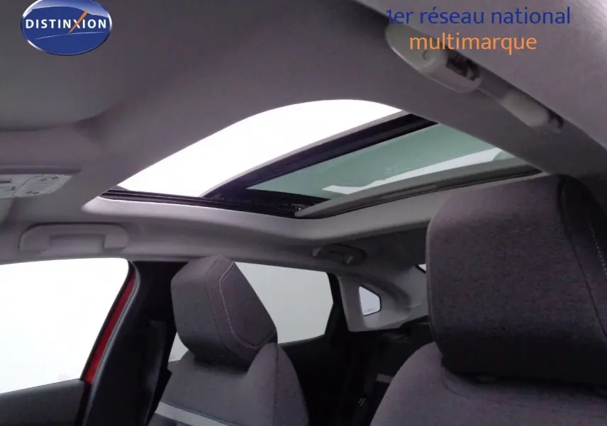 Vue intérieure sur les sièges avant gris et le toit ouvrant panoramique d'une Citroën C4 X rouge Elixir Metal.