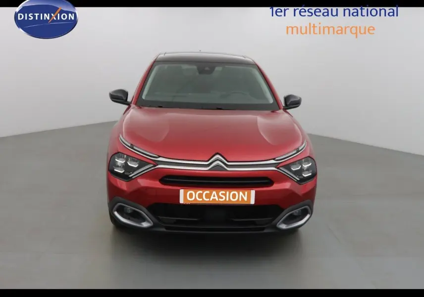 Vue frontale d'une Citroën C4 X rouge Elixir Métal 2023 avec calandre distinctive et feux LED allumés.
