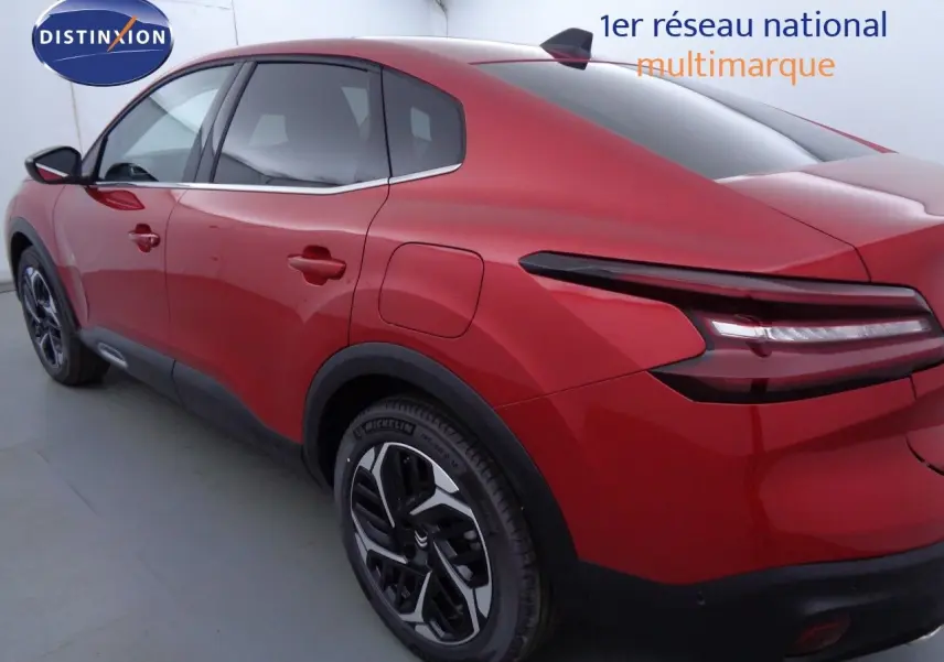 Vue 3/4 arrière droite d'une Citroën C4 X rouge Elixir métal avec feux arrière LED et jantes noires bicolores.