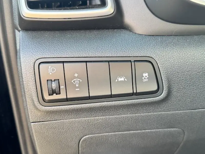 Gros plan sur les commandes de réglage des phares et d'aide à la conduite du Hyundai Tucson Phantom Black 2019.