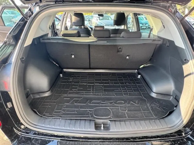 Coffre ouvert vu de l'arrière d'un Hyundai Tucson Phantom Black 2019 avec tapis de coffre marqué Tucson.
