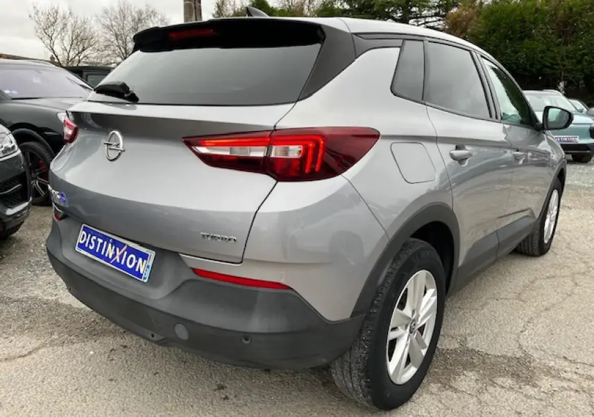 Vue 3/4 arrière droite d'un Opel Grandland X gris clair avec feux arrière LED et jantes alliage 17 pouces.
