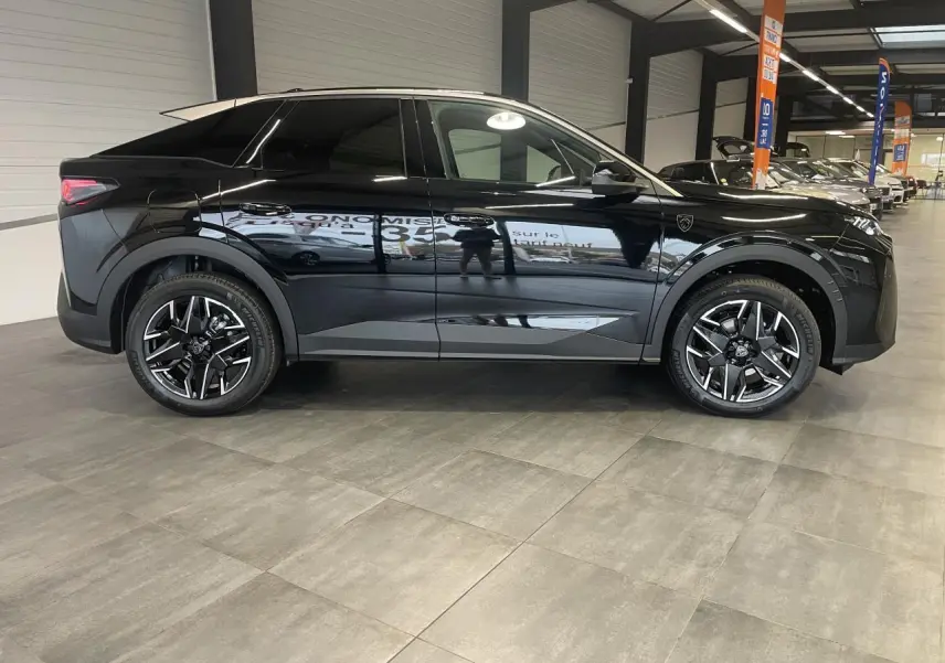 Peugeot 3008 GT noir métallisé vue de profil côté gauche en intérieur avec jantes alliage 19 pouces.