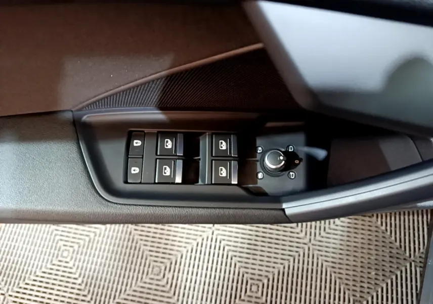 Vue rapprochée du panneau de commandes des vitres et rétroviseurs côté conducteur de l'Audi A3 gris foncé.