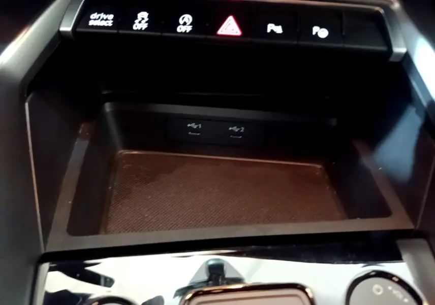 Vue rapprochée de la console centrale de l'Audi A3 gris foncé, avec boutons de contrôle et ports USB visibles.