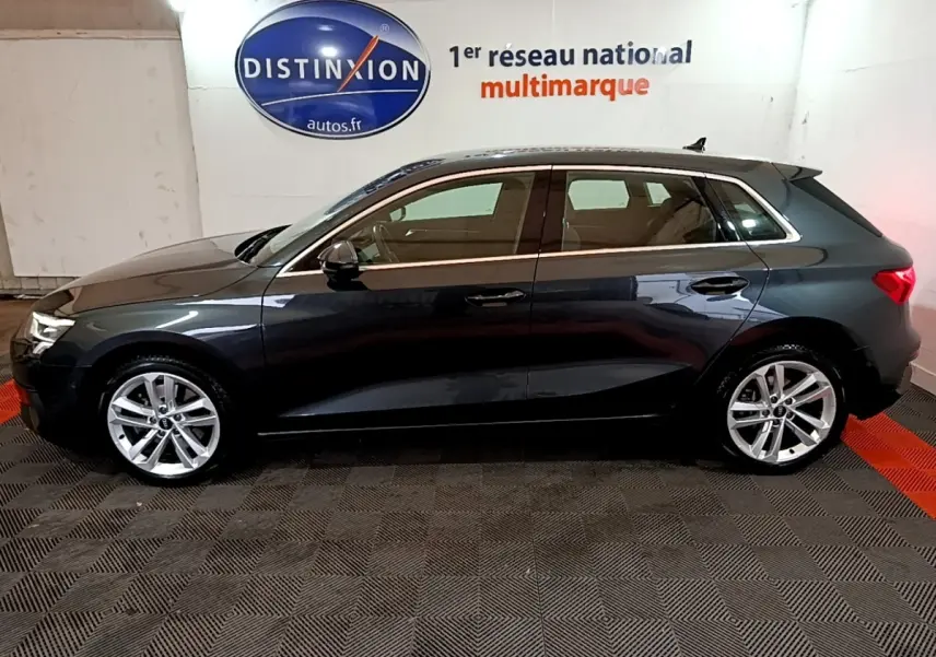Profil côté gauche d'une Audi A3 gris foncé 2021, version 35 TFSI MHEV, dans un showroom intérieur.