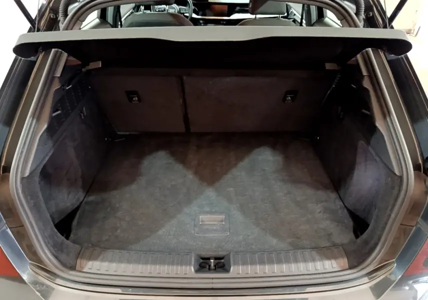 Vue arrière ouverte du coffre gris foncé de l'Audi A3 35 TFSI 150 MHEV Business Line, espace de chargement vide et propre.