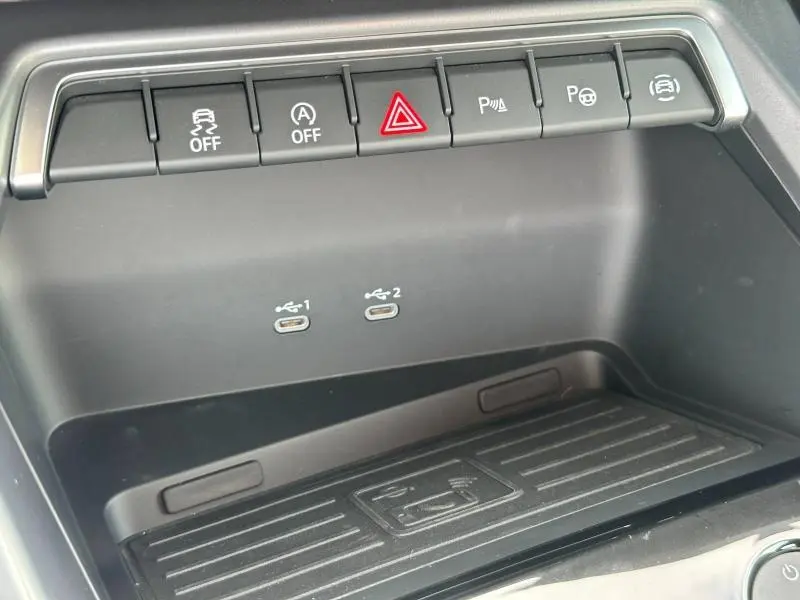 Détail de la console centrale noire de l'Audi A3 Sportback 2024 avec boutons de contrôle et ports USB-C doubles.