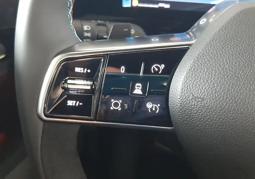 Gros plan sur les commandes de régulateur de vitesse au volant du Renault Austral E-Tech gris schiste satin.