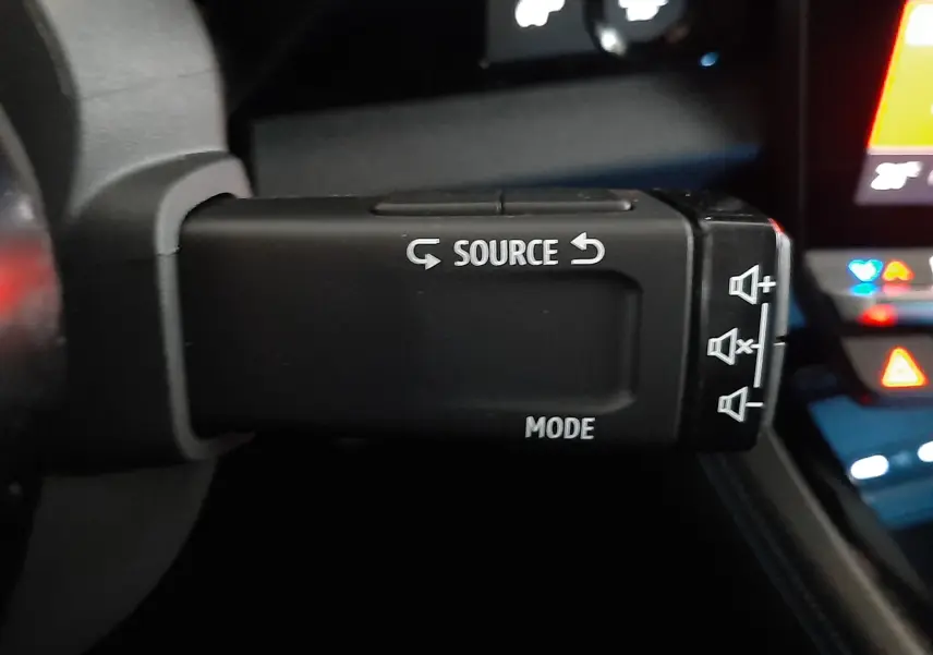 Commande au volant noir avec boutons "Source" et "Mode" dans l'habitacle du Renault Austral gris schiste satin.