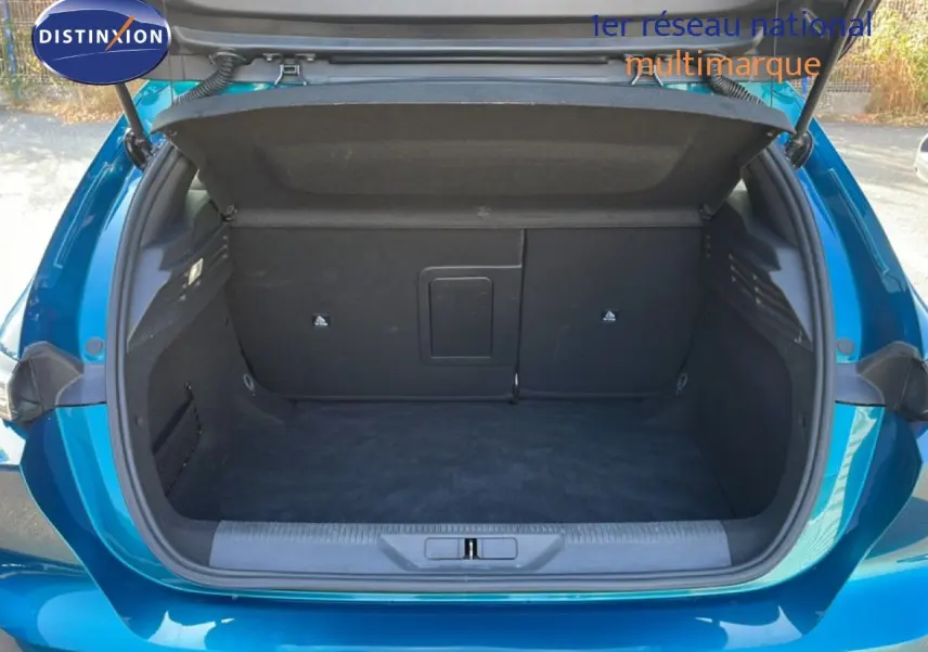 Coffre ouvert vu de l'arrière d'une Peugeot 308 1.2 PureTech 130ch Allure bleu obsession métal, espace de rangement vide.