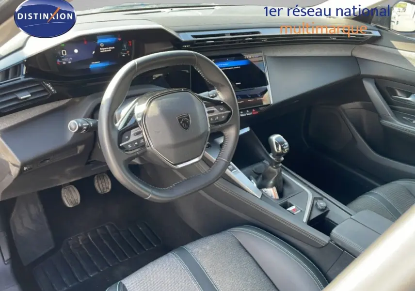 Vue intérieure côté conducteur de la Peugeot 308 1.2 PureTech 130ch Allure, volant cuir et boîte manuelle visibles.