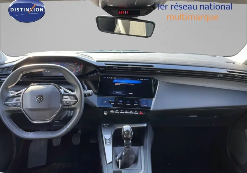 Vue intérieure avant du Peugeot 308 2024 avec volant compact, écran tactile central et levier de vitesse manuel.