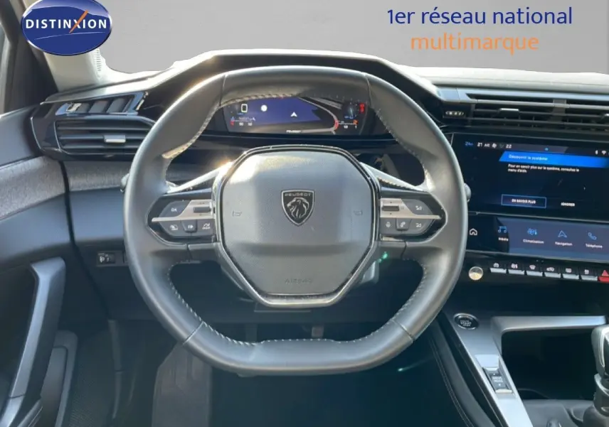 Vue intérieure centrée sur le volant cuir noir et le tableau de bord numérique de la Peugeot 308 2024.