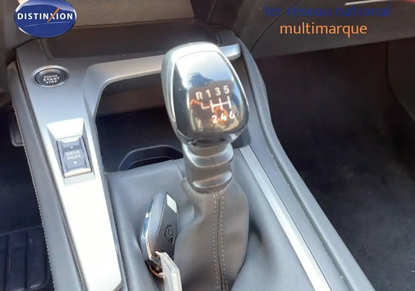 Gros plan sur la commande de boîte manuelle et la clé dans la console centrale d'une Peugeot 308 bleu Obsession Metal.