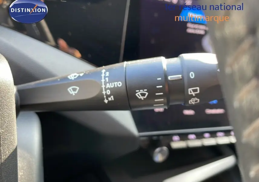 Gros plan sur la commande d’essuie-glace gauche dans l’habitacle d’une Peugeot 308 2024 bleu Obsession Metal.