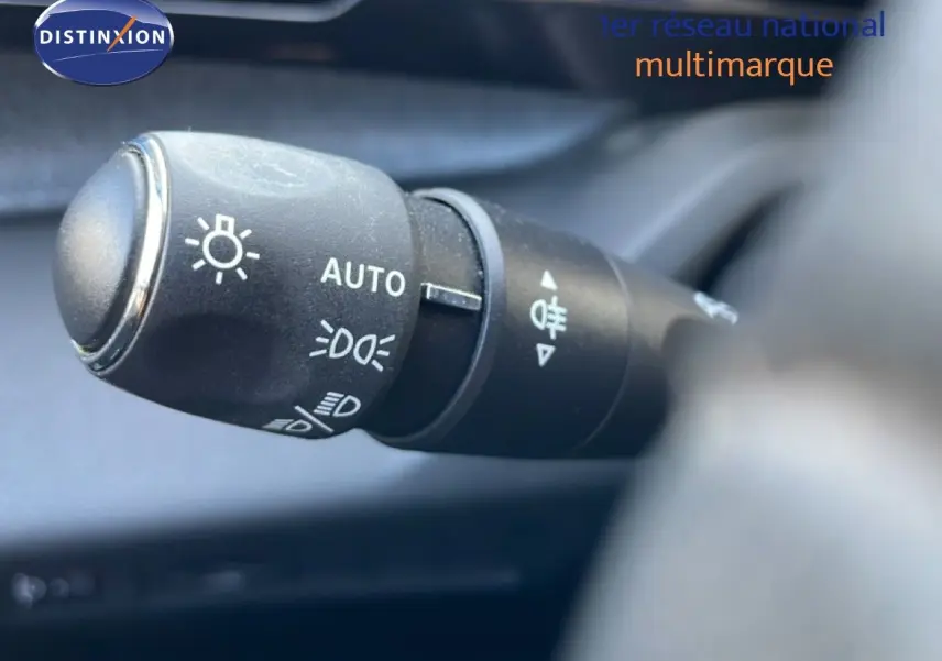 Gros plan sur la commande des phares automatiques dans l’habitacle d’une Peugeot 308 Bleu Obsession 2024.