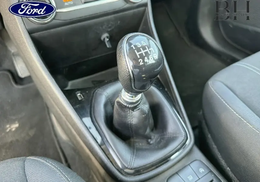 Gros plan sur le levier de vitesses manuel noir de la Ford Fiesta 2018, avec sièges tissu gris visibles autour.