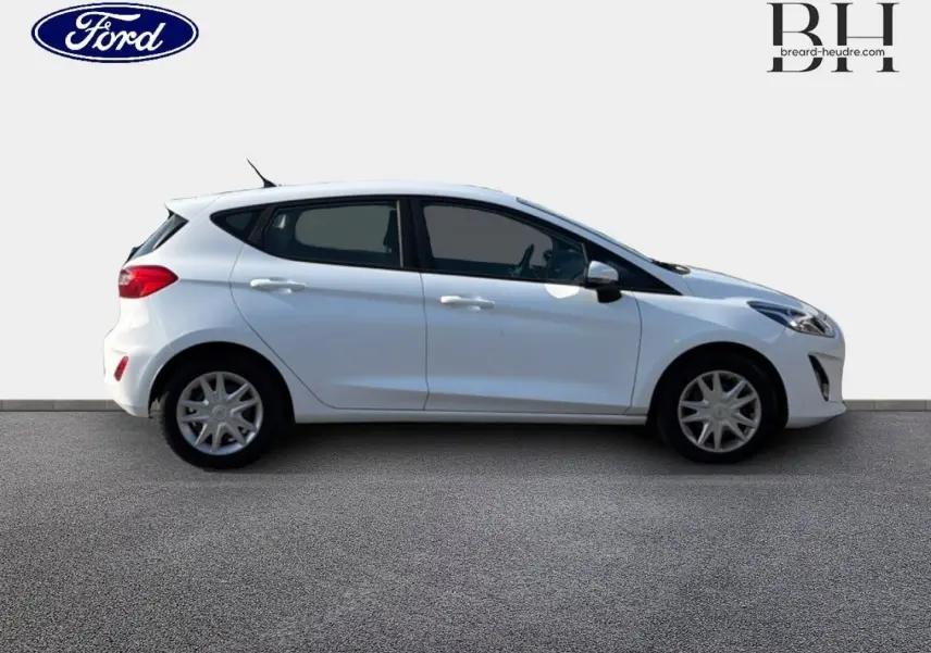 Vue de profil côté gauche d'une Ford Fiesta blanche Glacier 5 portes avec enjoliveurs et becquet arrière.