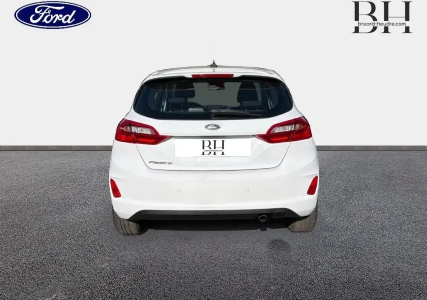 Vue arrière d'une Ford Fiesta blanche Glacier de 2018 avec feux rouges et becquet arrière visible.