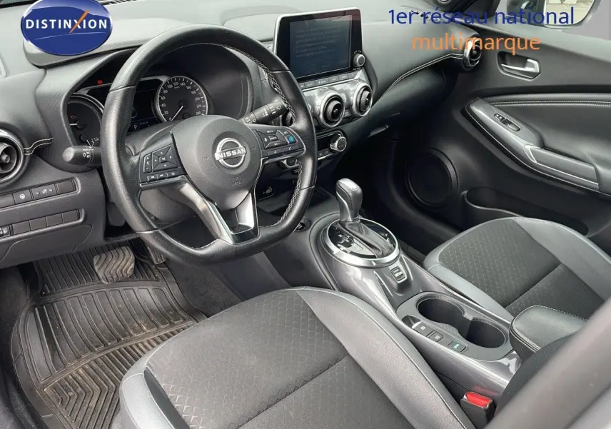 Intérieur du Nissan Juke Hybrid 2023 en gris perle, vue côté conducteur sur le tableau de bord et la console centrale.