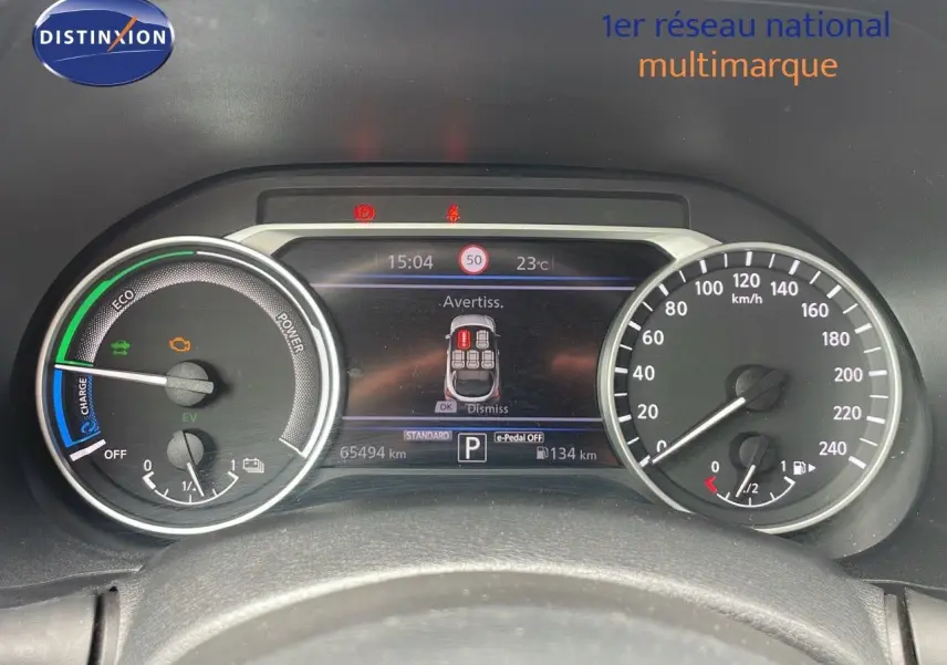 Tableau de bord du Nissan Juke Hybrid 2023 montrant les compteurs et l'écran d'alerte en affichage numérique.