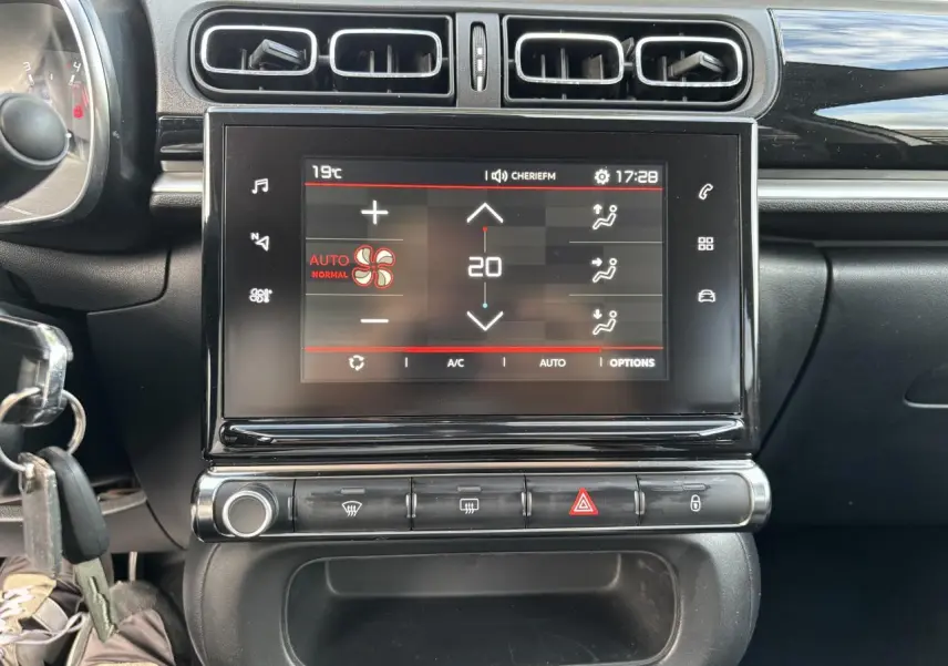 Tablette tactile centrale affichant la climatisation automatique dans l'habitacle noir d'une Citroën C3 2019.
