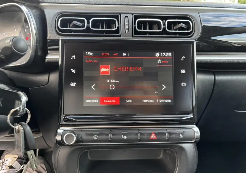 Vue rapprochée de la console centrale de la Citroën C3 2019, écran tactile affichant la radio Cherie FM.
