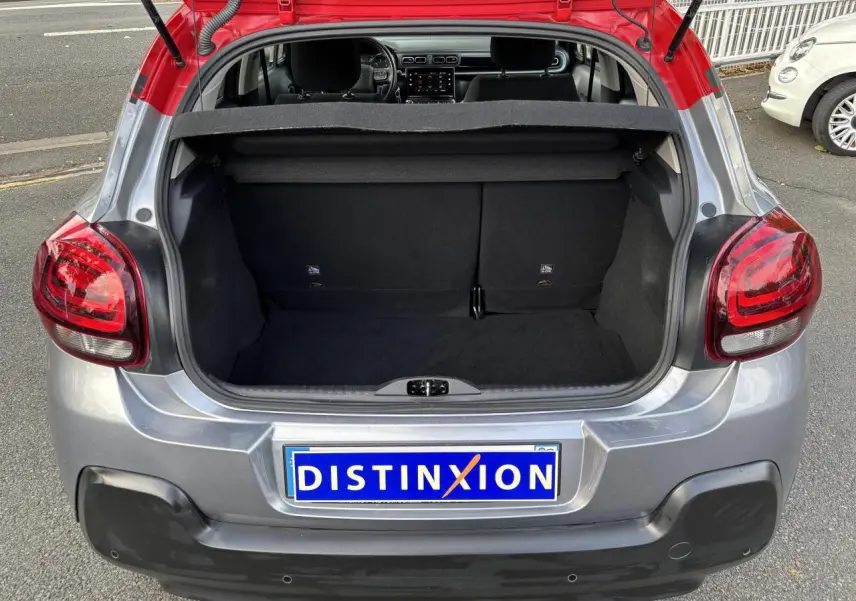 Coffre ouvert d'une Citroën C3 2019 gris avec toit rouge, vue arrière mettant en valeur les feux et le hayon.