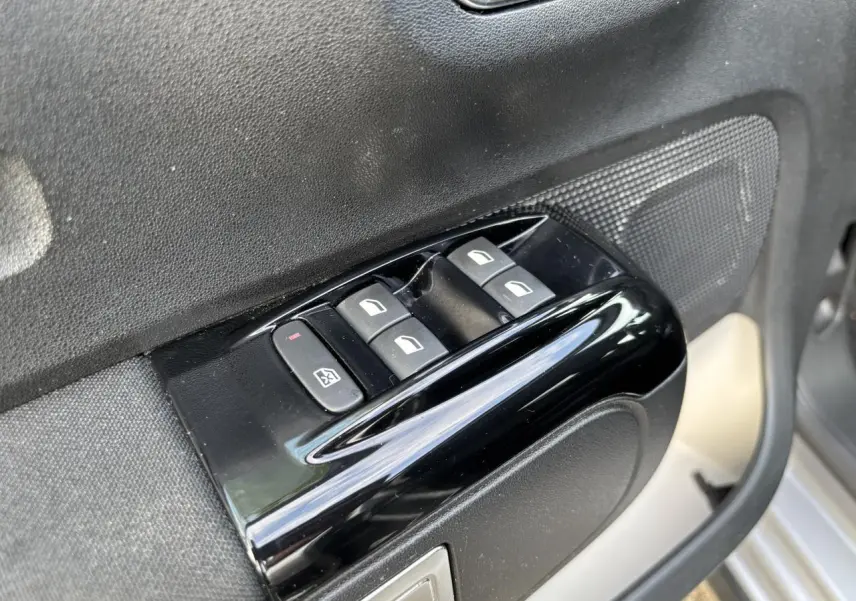 Gros plan sur les commandes des lève-vitres côté conducteur d'une Citroën C3 2019 gris avec toit rouge.